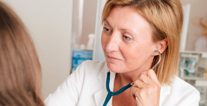 Ärztin mit Stethoskop untersucht Patient*in