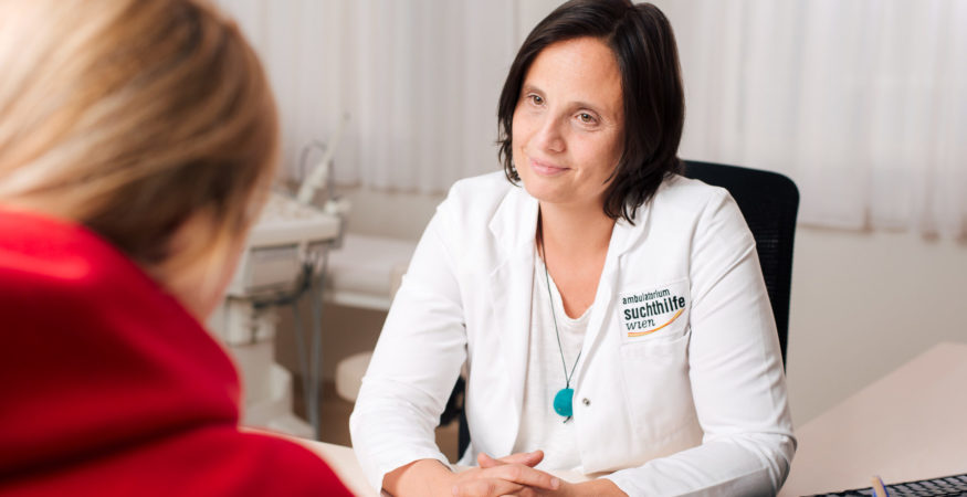 Eine Ärztin sitzt ihrer Patientin gegenüber und hört ihr aufmerksam zu