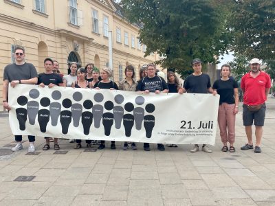 Der Betriebsrat der Suchthilfe Wien versammelt sich hinter dem Transparent zum Gedenktag