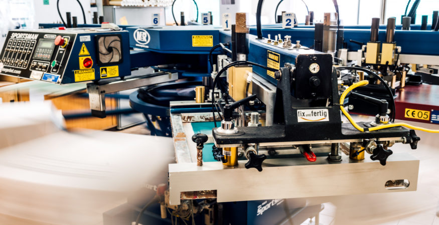 große Siebdruckmaschine im Bereich Textildruck von Fix und Fertig